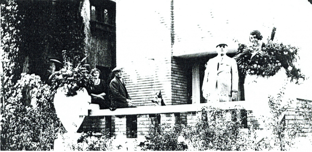 Photocopy from Erma K. Bours’ album, in the possession of her niece Joyce Page in 1999. Pictured on the front patio of the house Erma and Dr. Thomas Robinson Bours had built in 1921-22 at what is now 2430 E. Newberry Blvd. are, from right to left, Erma K. Bours, Dr. Thomas Robinson Bours, their German Shepherd “King,” their architect Russell Barr Williamson, and Nola Mae Williamson. 