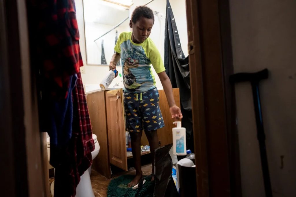 Aidan Branch, now 10, packs items from the bathroom of the Milwaukee apartment his mom and two siblings were moving out of on July 1, 2023. Aidan suffered severe lead poisoning in the apartment where the family previously lived. Lead is a neurotoxin that damages the brain and nervous system, especially in young children. (Sara Stathas for Wisconsin Watch)