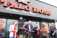 Taj Pearsall (second from left) and Alderman Robert Bauman cut the ribbon at the grand opening for Buffalo Boss, 540 N. 27th St. Photo taken Sept. 28, 2023 by Sophie Bolich.