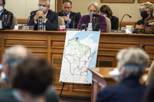 A map created by Republicans in the state Legislature is displayed during a hearing on Oct. 28, 2021, at the Wisconsin State Capitol. Sen. Jeff Smith sits on the left. Angela Major/WPR