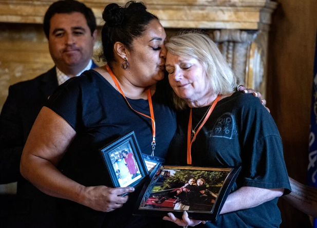 Marlena Banks, left, and Cheryl Rohloff, right, hold photos of their family member, Tommy Shaw, who was a victim of gun violence Thursday, Sept. 21, 2023, during a press conference at the Wisconsin State Capitol in Madison, Wis. Angela Major/WPR