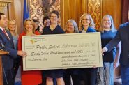 Wisconsin state and educational officials hold a giant mock check to promote the upcoming distribution of funds for Wisconsin school libraries. Among those pictured are, from left, Attorney General Josh Kaul, Wisconsin Education Association Council President Peggy Wirtz-Olsen, Superintendent of Public Instruction Jill Underly, President Kay Koepsel-Benning of the Wisconsin Educational Media & Technology Assn., Wisconsin Secretary of State Sarah Godlewski, WEMTA Treasurer Emily Dittmar and Wisconsin State Treasurer John Leiber. (Wisconsin Examiner photo)