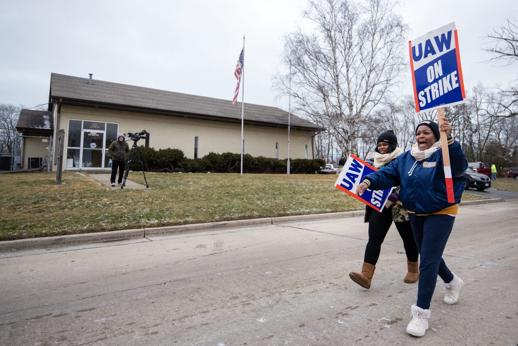 Attendees at the rally for striking Case truck factory workers hold signs as they exit Saturday, Dec. 17, 2022, at the United Auto Workers hall in Racine, Wis. Angela Major/WPR
