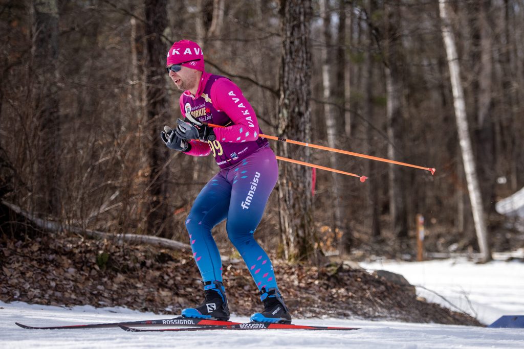 A skier passes by a wooded area while racing on manmade snow Saturday, Feb. 24, 2024, at the American Birkebeiner Ski Race in northern Wisconsin. Angela Major/WPR