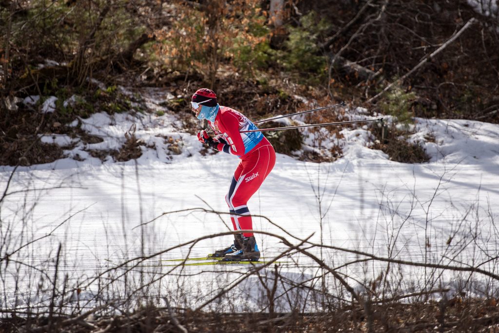 A skier travels on manmade snow through a wooded, snowless area Saturday, Feb. 24, 2024, at the American Birkebeiner Ski Race in northern Wisconsin. Angela Major/WPR