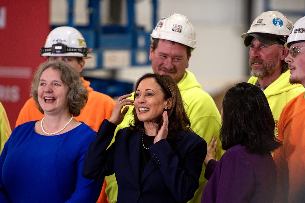 Vice President Kamala Harris, center, takes a photo with Madison Mayor Satya Rhodes-Conway, left, Acting Secretary of Labor Julie Su, right, and the apprentices Wednesday, March 6, 2024, during a visit to Madison, Wis. (Angela Major/WPR)