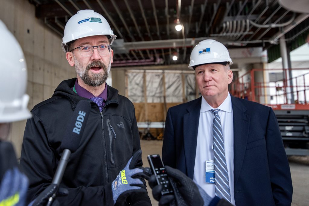 Senior project manager Jeff Senn, left, and Chairman of Radiation Oncology at Medical College of Wisconsin Christopher Schultz, right, speak to reporters during a tour of the construction site Thursday, March 7, 2024, at Froedtert & Medical College of Wisconsin in Milwaukee, Wis. Angela Major/WPR
