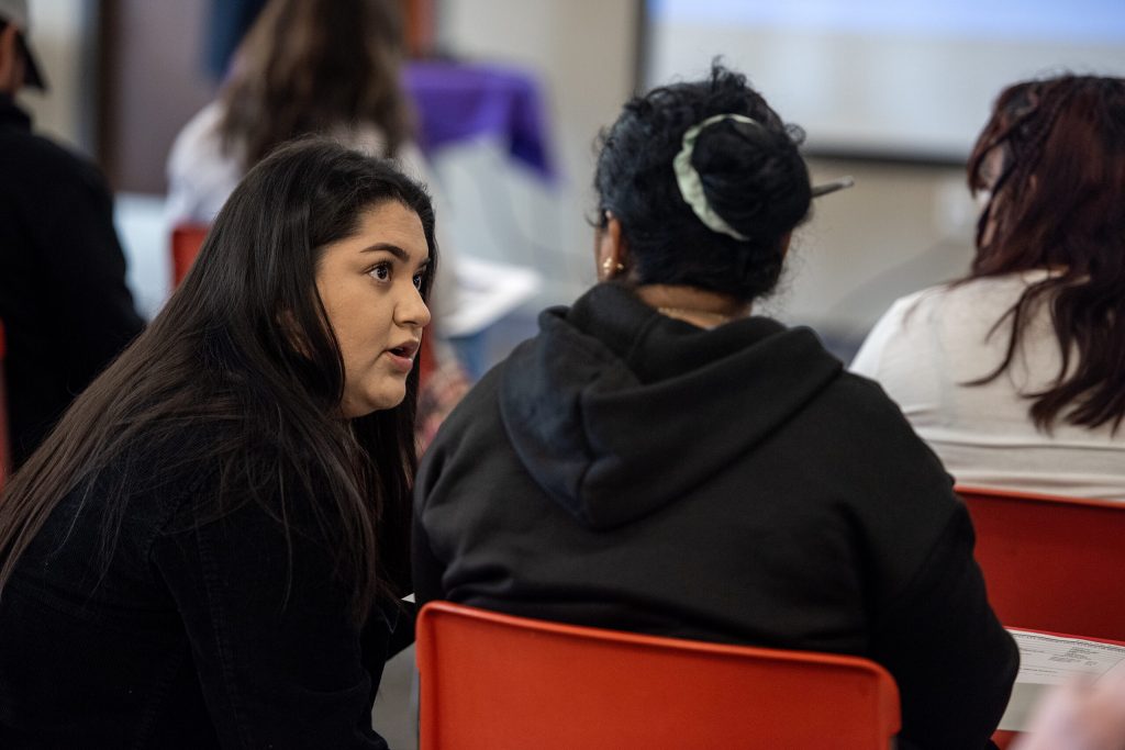 Yesenia Villalpando-Torres, a social worker with Dane County’s Immigration Affairs office, speaks to a seminar attendee Monday, March 11, 2024, in Madison, Wis. The Immigration Affairs office was on hand to connectnew arrivals to social services and other resources. Angela Major/WPR