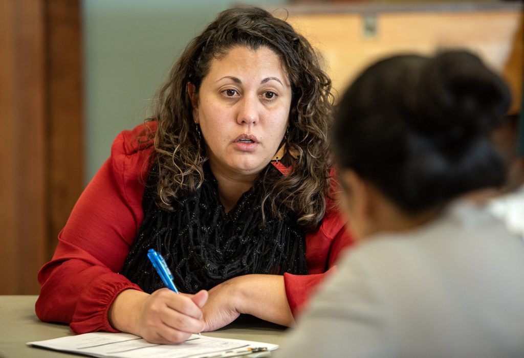 Charlyn Cruz Nuñez, a social worker with Dane County’s Immigration Affairs office, works with an attendee after a seminar on Monday, March 11, 2024, in Madison, Wis. Angela Major/WPR