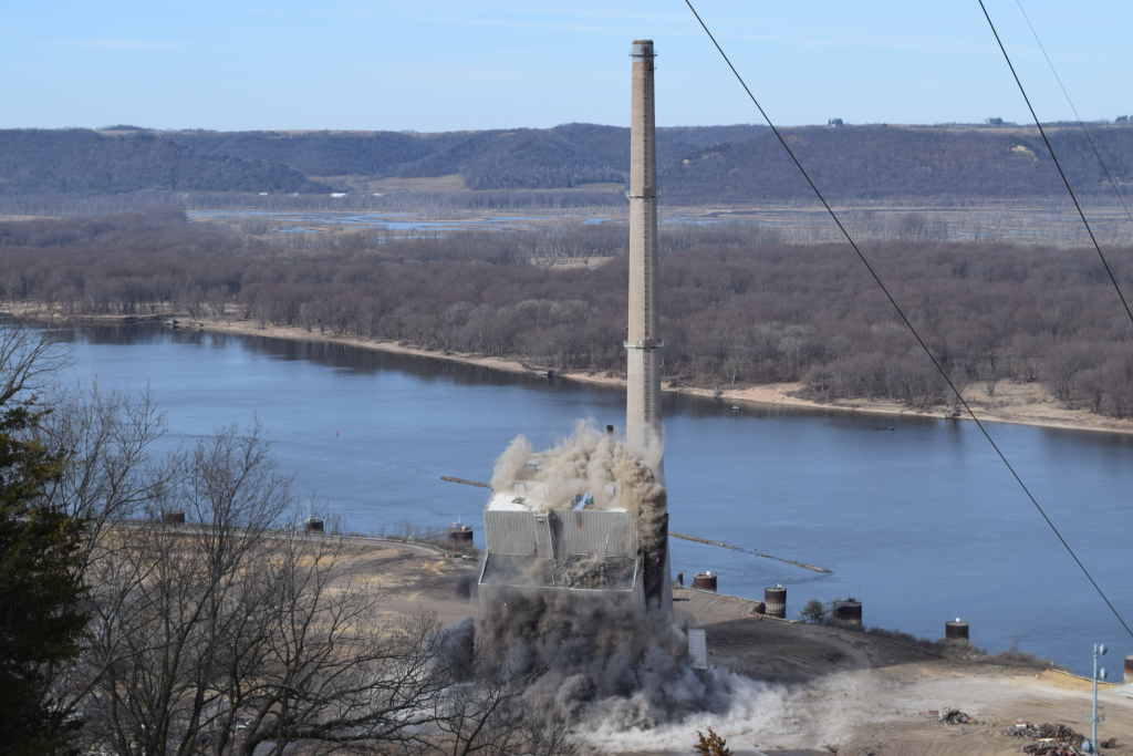 The boiler house and chimney stack at the Genoa power plant during demolition on Tuesday, March 19, 2024. Hope Kirwan/WPR