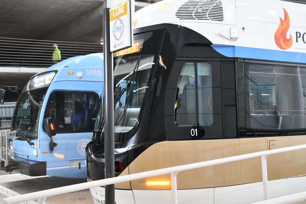 A Connect 1 battery electric bus (left) and The Hop streetcar vehicle (right) at The Couture transit concourse. Photo by Jeramey Jannene.