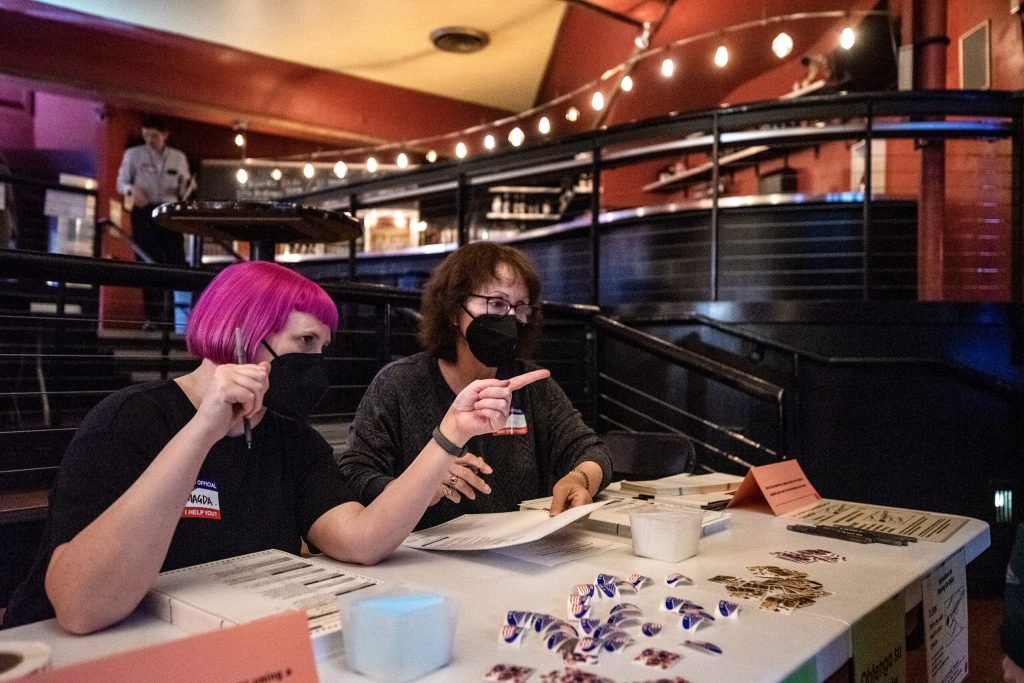 Poll workers sit at a table as voters come through Tuesday, April 4, 2023, at Majestic Theatre in Madison, Wis. Angela Major/WPR