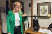 Wisconsin Secretary of State Sarah Godlewski with the machine that affixes the Great Seal of Wisconsin | Wisconsin Examiner photo