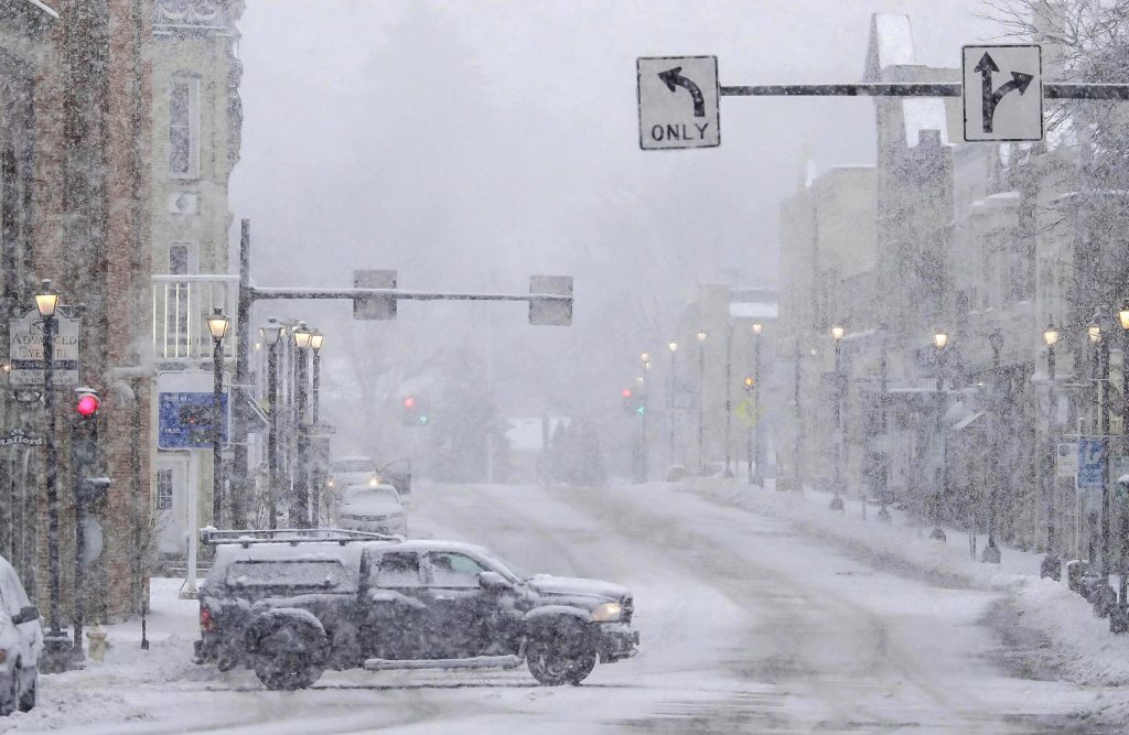 A truck crosses an intersection in Plymouth, Wis., during a Jan. 9, 2024, winter storm that prompted power outages across Wisconsin. The outages caused food spoilage in some households, but not all FoodShare recipients knew they could request replacement benefits to purchase fresh food. (Gary C. Klein / USA TODAY NETWORK-Wisconsin)