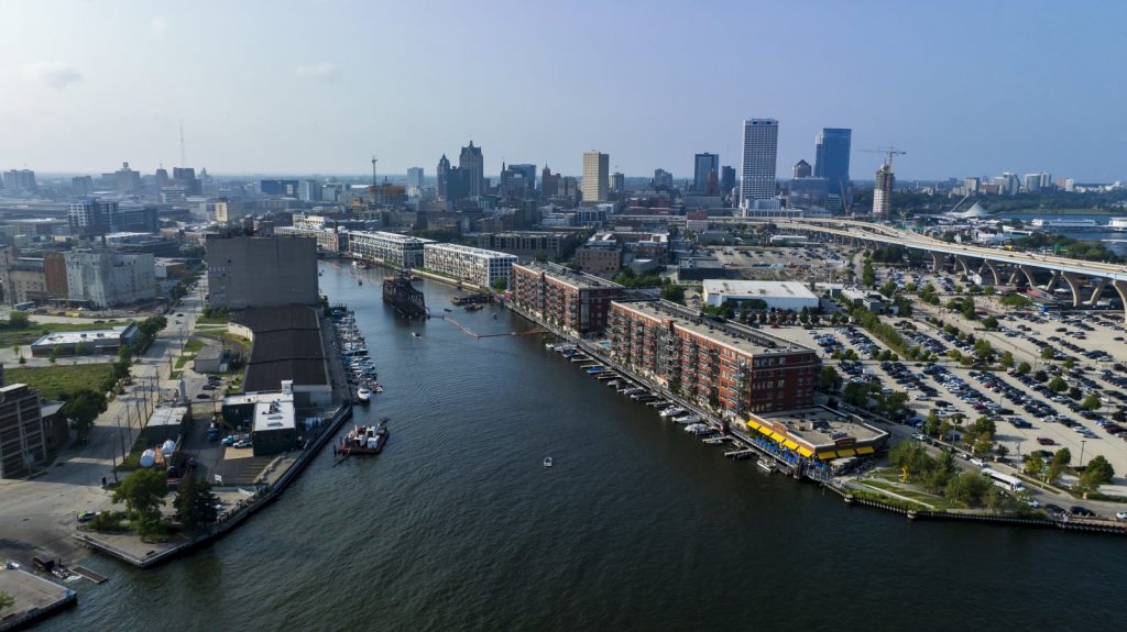 Drone photo of Milwaukee’s inner harbor. Floating orange booms along the Milwaukee River during the 2023 We Energies dredging project are visible. The contaminated dredged materials from the river bottom were piped to the Confined Disposal Facility. WCMP did not fund the drone photography, which is used with permission. Photo by @Eric Halvie.
