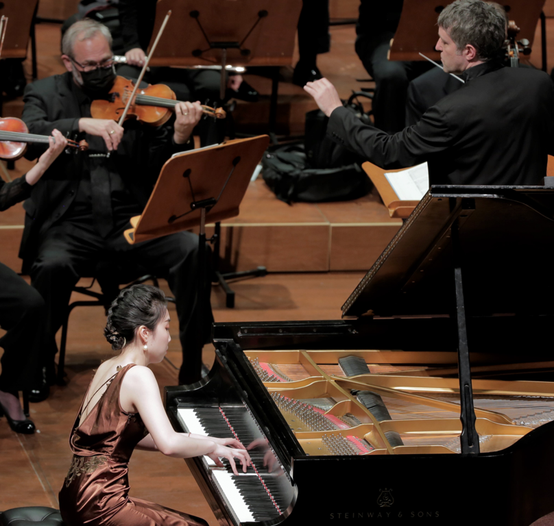 Ailun Zheng performing in the 2022 North American Piano Competition with the Milwaukee Symphony Orchestra and Conductor Yaniv Dinur. Photo courtesy of PianoArts.