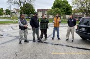 Sup. Juan Miguel Martinez (center) holds a press conference in Mitchell Park parking lot. Vaun Mayes stands to his right. Walter Garron and park ranger program lead Todd Pisarski stand to his left. Photo by Graham Kilmer.