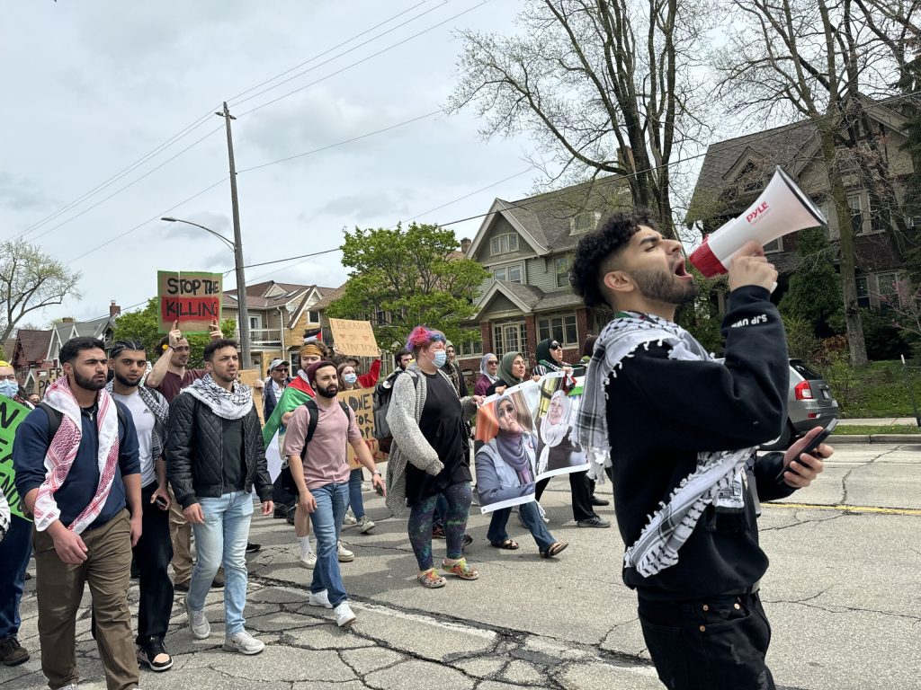 Zaid Dahir, a junior at UW-Milwaukee and a representative for the Milwaukee Muslim Student Association, leads a Pro-Palestinian march outside of the UW-Milwaukee campus on Monday, April 29, 2024. Evan Casey/WPR