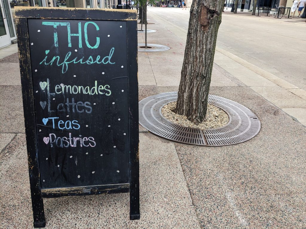 A chalkboard sign on State Street in Madison advertises THC-infused drinks and pastries. Richelle Wilson/WPR