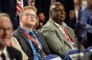 24-year-old Wisconsin delegate Dixon Wolfe, left, who also serves as a member of the Brown County Board of Supervisors, listens to speakers during the second day of the RNC on Tuesday, July 16, 2024, at the Fiserv Forum in Milwaukee, Wis. Angela Major/WPR