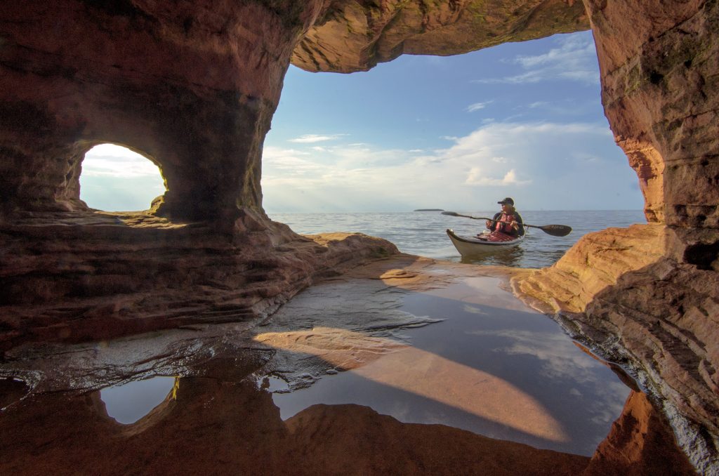 A kayaker exploring the Apostle Island sea caves. Photo courtesy of Jeff Rennicke