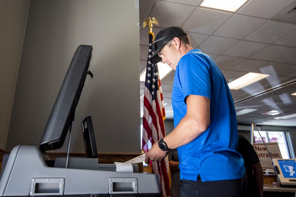 Ryan Bedford puts a ballot into a machine while voting Tuesday, Aug. 9, 2022, at the Village of Waukesha Municipal Complex. Angela Major/WPR