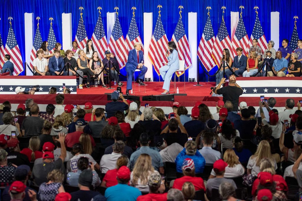 Former President Donald Trump speaks with former U.S. Rep. Tulsi Gabbard at a campaign rally on Aug. 29, 2024 at the La Crosse Center in La Crosse, Wis. Angela Major/WPR