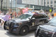 Marchers walk past two Milwaukee Police Department vehicles on the first day of the Republican National Convention last month. During the convention, the lawsuit opposing the new video footage release policy was dropped. Photo by Devin Blake/NNS.