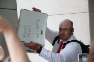 Matthew Snorek, one of the organizers of an effort to recall Assembly Speaker Robin Vos, holds up a box of what he says contains more than 9,000 signatures. Shawn Johnson/WPR