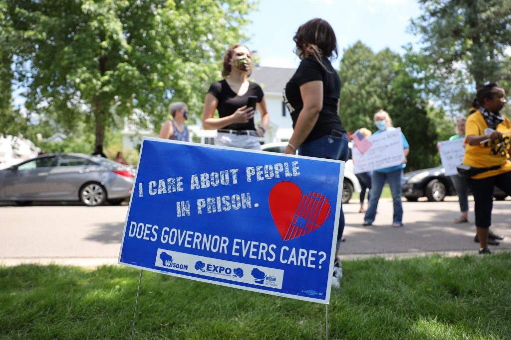 Signs and posters are seen outside the governor’s mansion in Madison, Wis., on June 18, 2020, as part of a “Drive to Decarcerate” rally. The goal of the rally was to urge Gov. Tony Evers to follow through on a campaign goal to reduce Wisconsin’s prison population. (Coburn Dukehart / Wisconsin Watch)