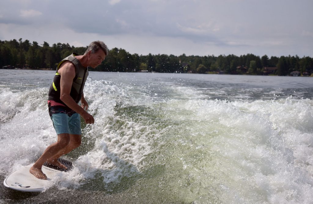 Mark Mapes wake surfs on Lake Minocqua on July 22, 2024. Danielle Kaeding/WPR