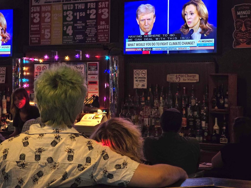 A couple watches the Sept. 10 presidential debate between former Republican President Donald Trump and Vice President Kamala Harris during a watch party at Scooters Bar in Eau Claire. Rich Kremer/WPR