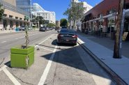 Drivers illegally parked in the damaged protected bike lane in September 2024. Photo by Jeramey Jannene.