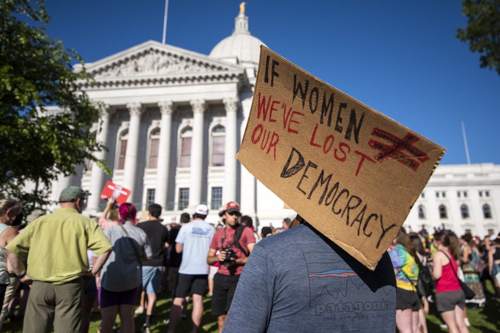 A protester holds a sign during a protest in opposition to the Supreme Court’s decision to overturn Roe vs. Wade on Friday, June 24, 2022, in Madison, Wis. Angela Major/WPR