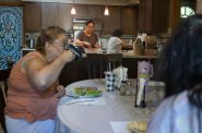 Rosa Landa, owner of Good Hand Care AFH, second from left, makes lunch for the facility’s residents on Aug. 23, 2024, in Madison, Wis. Landa considered closing the facility before a slight Medicaid reimbursement hike allowed the home to survive. (Joe Timmerman / Wisconsin Watch)