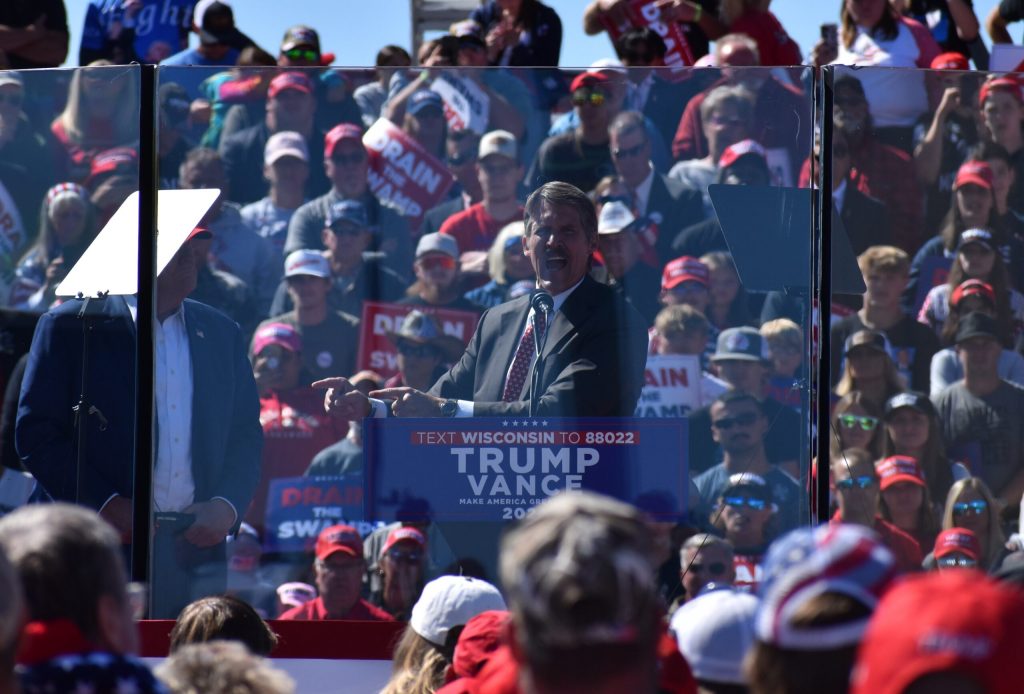 Republican U.S. Senate candidate Eric Hovde speaks at the Trump rally in Mosinee on Sept. 7, 2024, while Trump looks on. Rob Mentzer/WPR