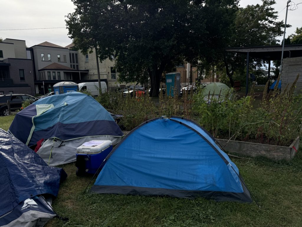 A fence surrounds an outdoor encampment Thursday, May 9, 2024, in Milwaukee, Wis. Angela Major/WPR