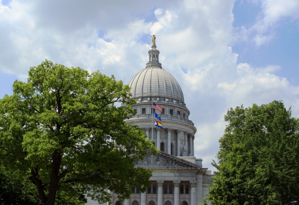 A Progress Pride flag flies over the Wisconsin State Capitol. (Henry Redman | Wisconsin Examiner)