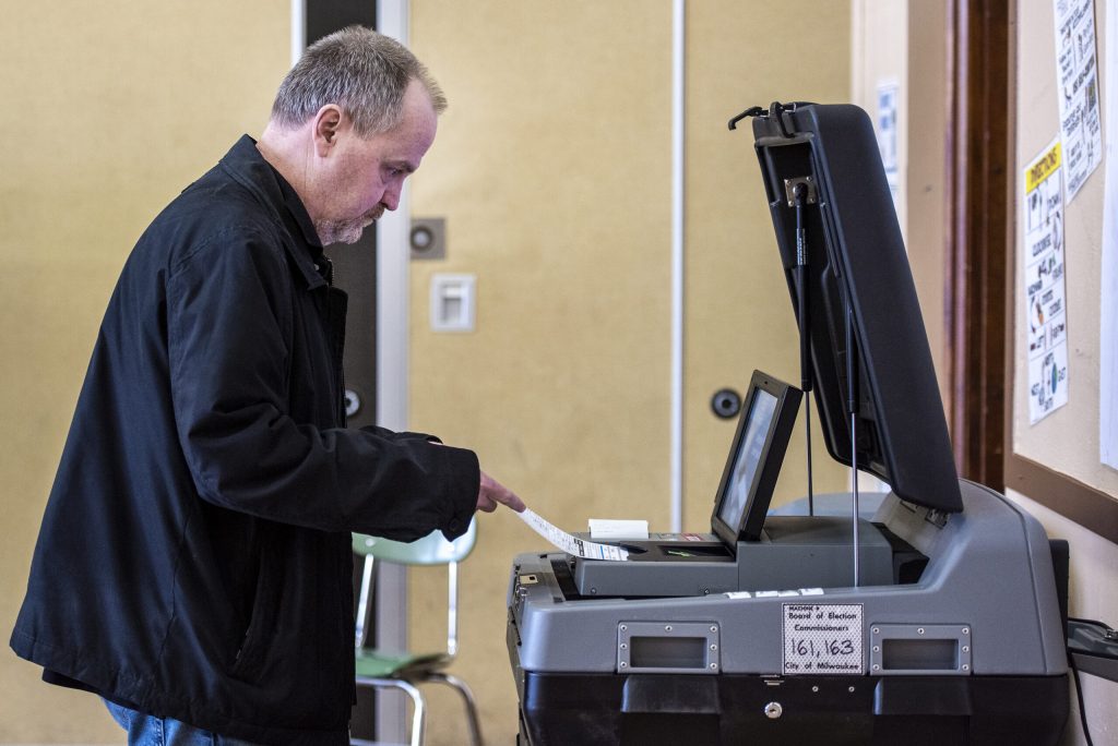 Milwaukee resident Troy Boeldt inserts his ballot into a reading machine after filling it out Tuesday, April 5, 2022, at the Milwaukee French Immersion School in Milwaukee, Wis. Angela Major/WPR