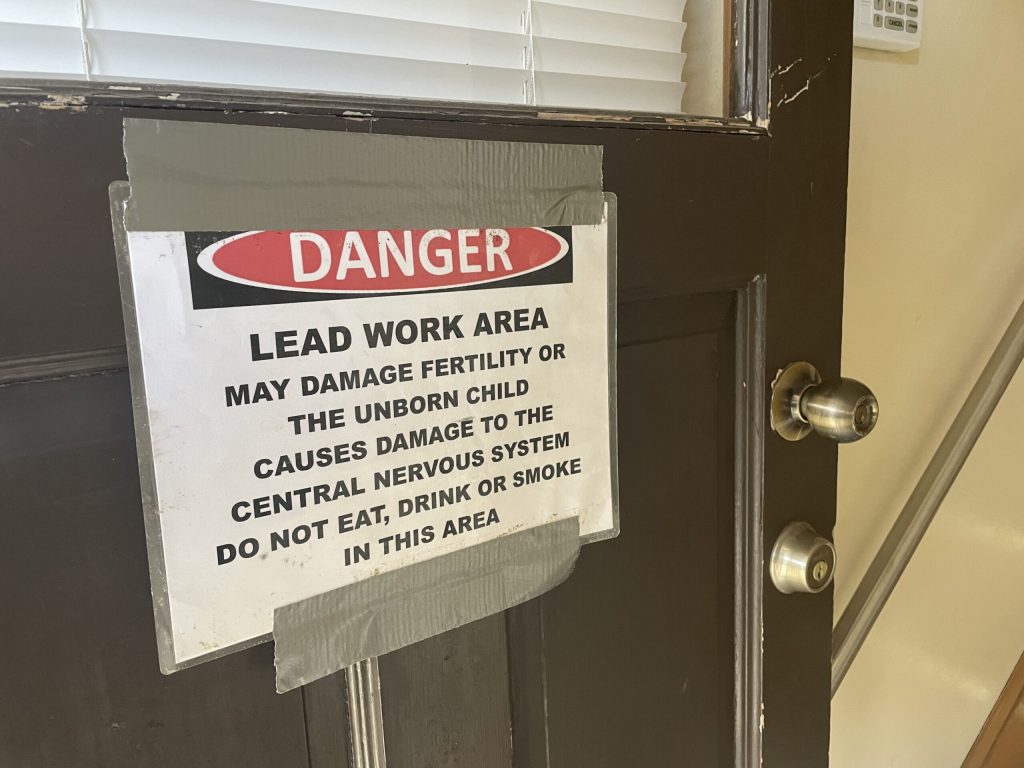 A sign on the back door of a house on Milwaukee’s North Side warns of lead abatement work on Oct. 23, 2024. Nick Rommel/WPR