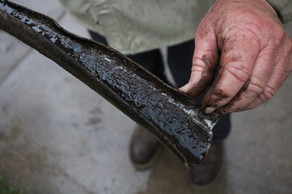 Montana Birt of Montana and Son Grading shows the worn-down protective coating of an old lead service pipe on June 29, 2021. The pipeline was removed from a home in Eau Claire, Wis., as part of a citywide initiative to replace potentially hazardous lead pipelines with those made of copper or plastic. Madeline Fuerstenberg/Wisconsin Watch