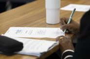 Commissioner Donna Brown-Martin writes on a copy of the agenda of the Social Development Commission’s board meeting in September. She is one of three commissioners who have resigned in the past week. (Photo by Joe Timmerman / Wisconsin Watch)