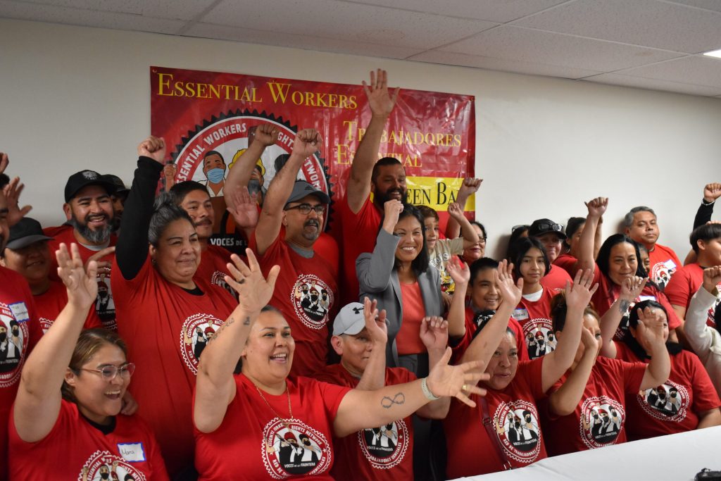 U.S. Department of Labor Secretary Julie Su, middle, pumps a fist while standing with immigrants in Green Bay on Monday, Sept. 9, 2024. Joe Schulz/WPR