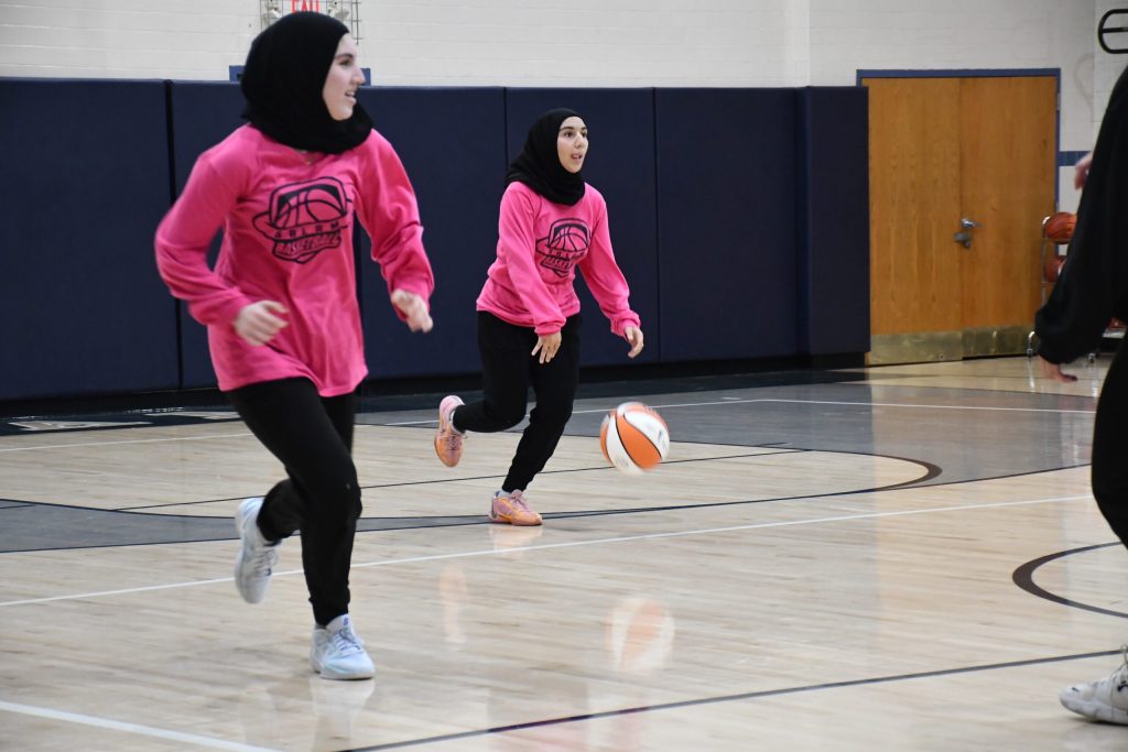 Junior Maysem Abubaker drives up the court during a Salam Stars basketball game. Mackenzie Krumme/WPR