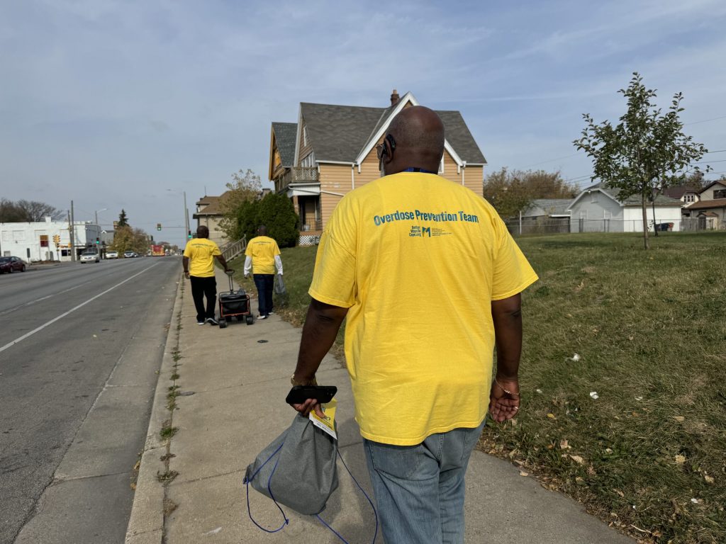 Ricky Person, right, holds a resource bag filled with Narcan and fentanyl test strips. Evan Casey/WPR