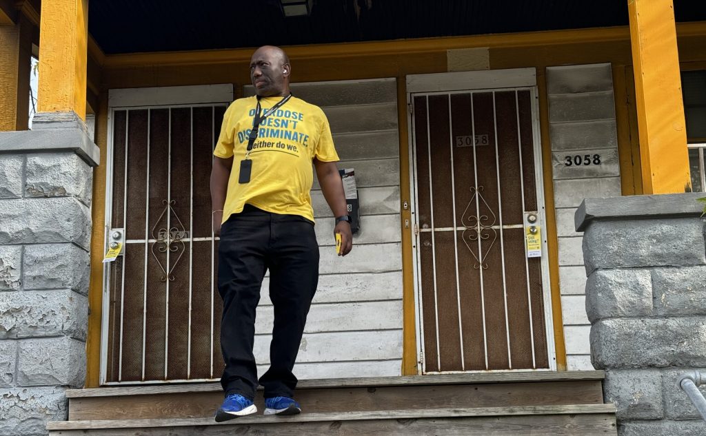 Sean Braxton with Milwaukee County knocks on door in the city’s Sherman Phoenix neighborhood. Evan Casey/WPR