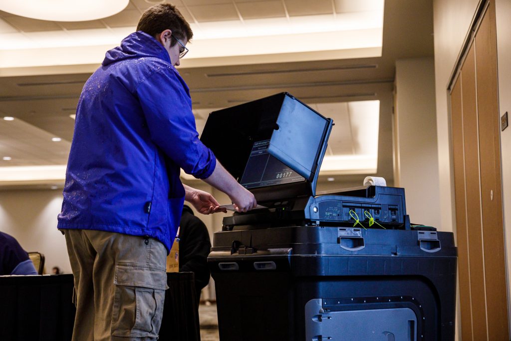 UW-Oshkosh student Theodorus Guigley casts a ballot. (Julius Shieh / Wisconsin Watch)