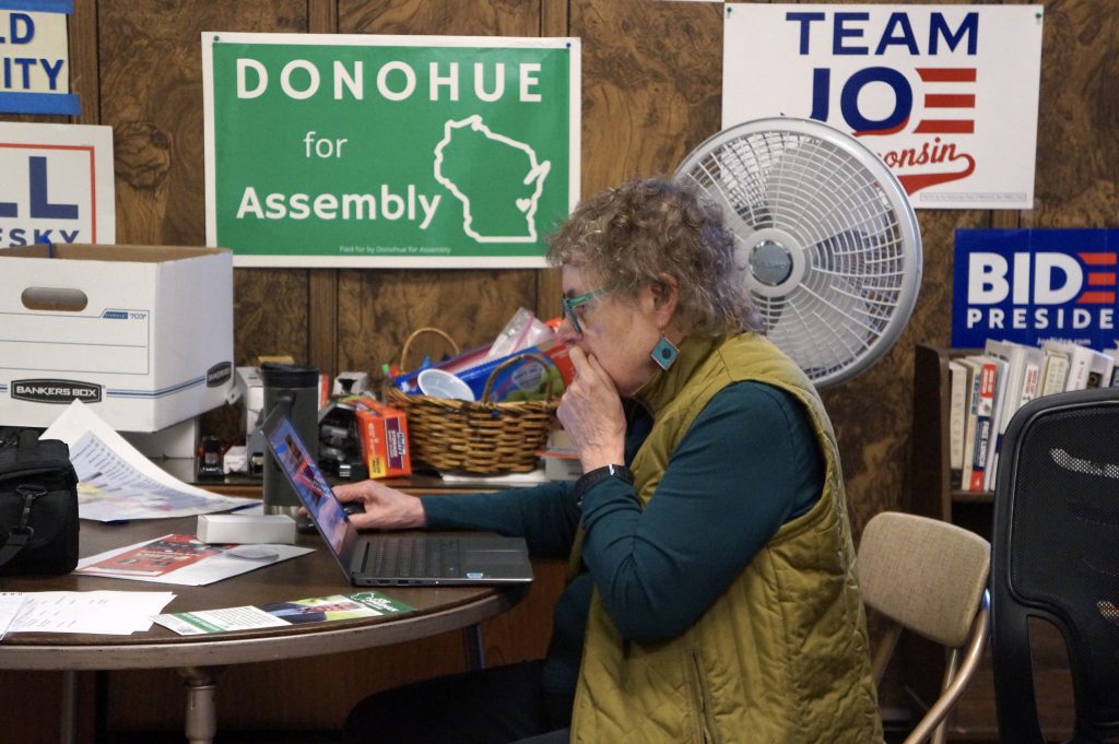 At the Sheboygan County Democratic Party headquarters on Nov. 5, 2024, local party co-chair Mary Lynne Donohue sits at her computer. Donohue ran for Assembly in 2020 as a “sacrificial lamb” because she lived in a Sheboygan district that had been gerrymandered to prevent Democrats from winning. On Tuesday her party won the new Sheboygan district made possible by new legislative maps. (Hallie Claflin / Wisconsin Watch)