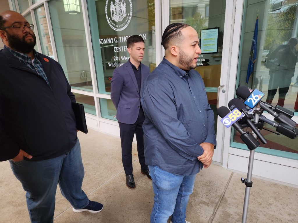 Flanked by Sam Liebert, left, and Scott Thompson, center, Nick Ramos of the Wisconsin Democracy Campaign addresses reporters Thursday outside a Wisconsin state office building. The three criticized Republican Senate candidate Eric Hovde for not conceding after vote tallies reported that Democratic Sen. Tammy Baldwin finished the election with 29,000 more votes than Hovde. (Wisconsin Examiner photo)