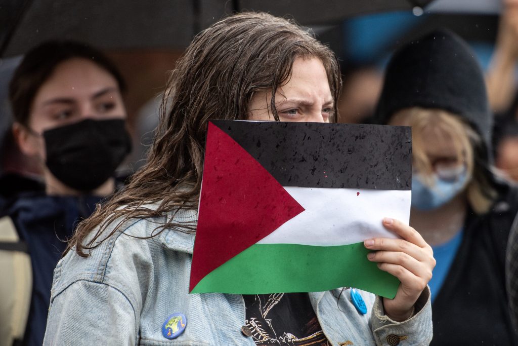 A protester holds a Palestinian flag during a demonstration Monday, April 29, 2024, at the University of Wisconsin-Madison in Madison, Wis. Angela Major/WPR